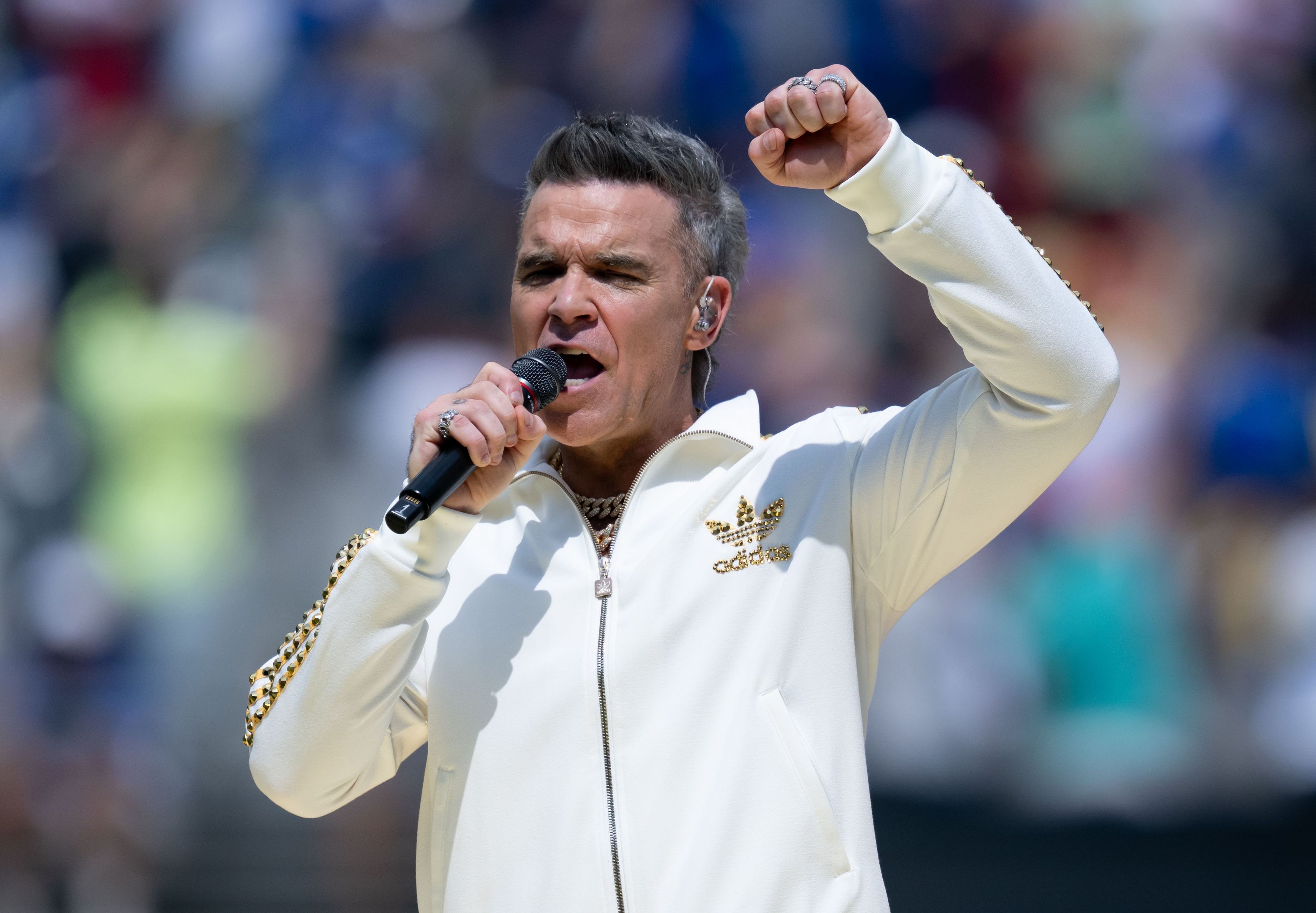 Robbie Williams singt ins Mikrofon
