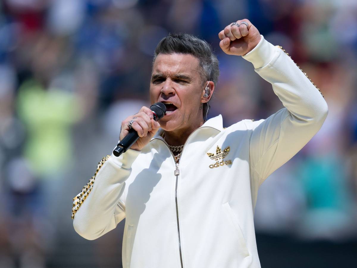 Robbie Williams singt ins Mikrofon