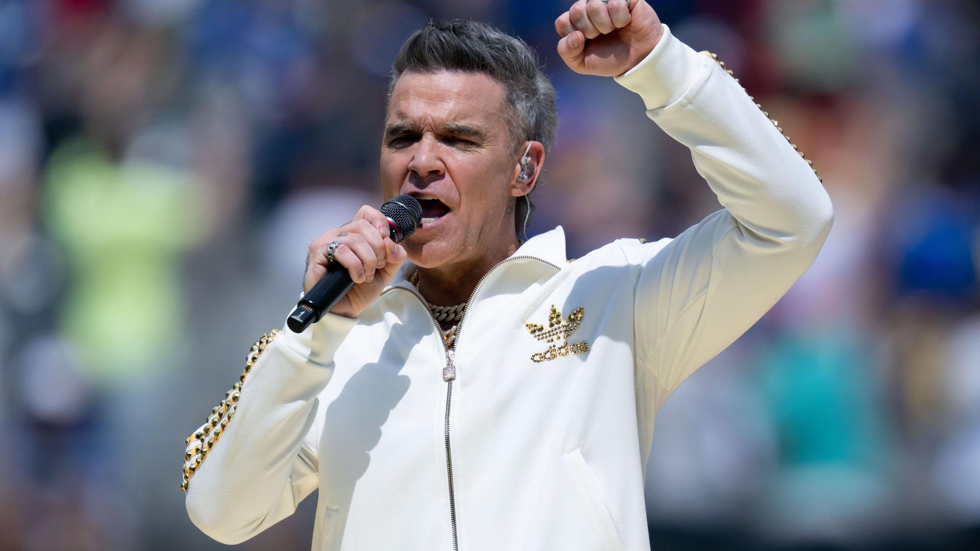 Robbie Williams singt ins Mikrofon
