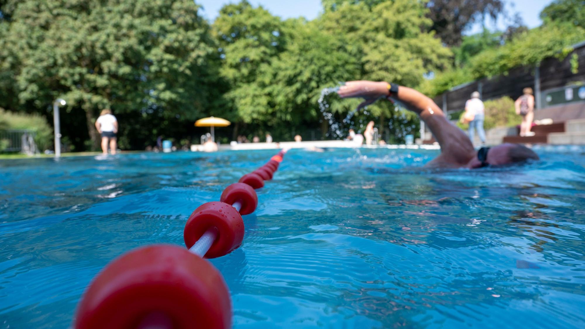 Eine Person im Freibad krault durchs Becken.