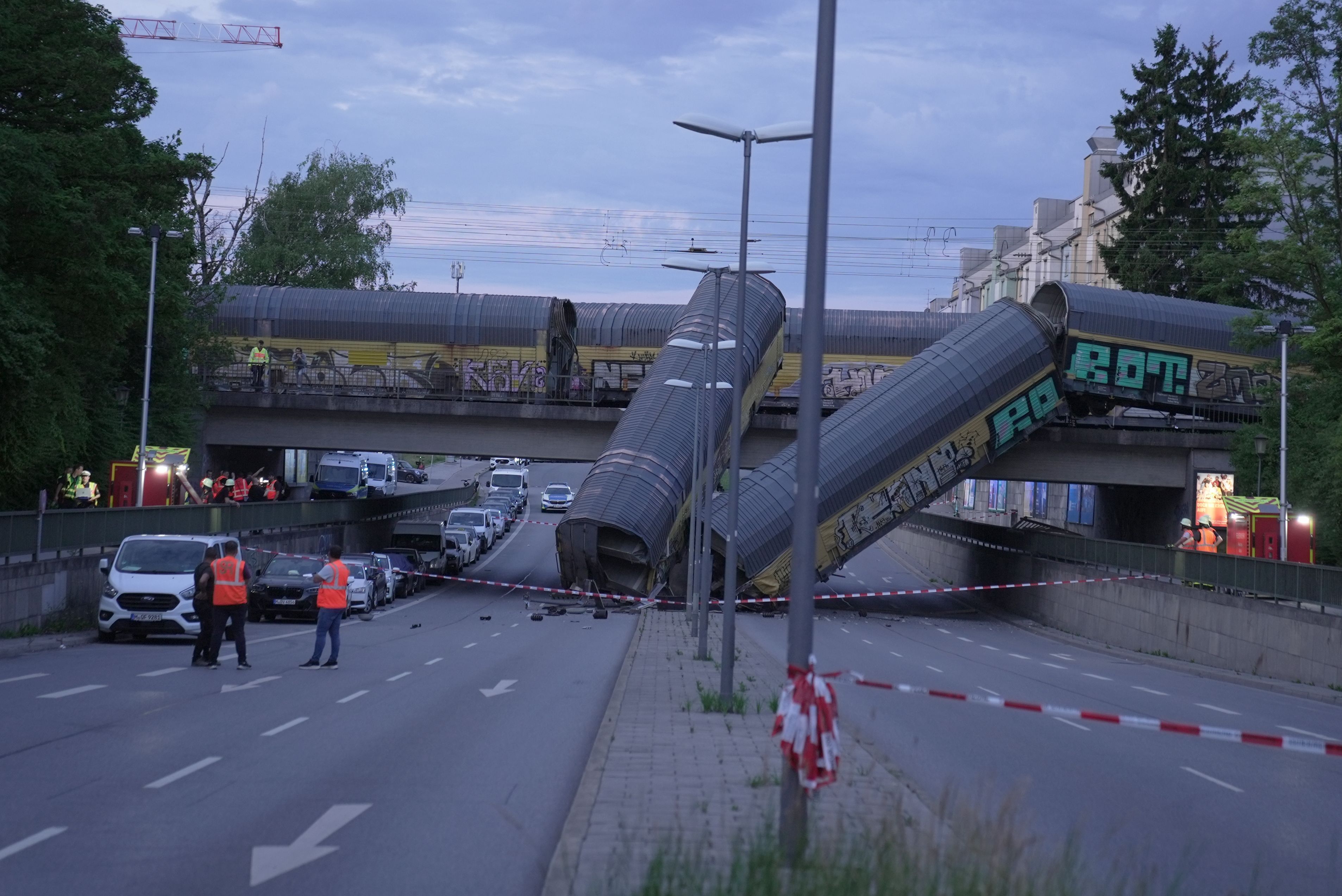 Zwei Waggons eines Güterzugs liegen auf einer Straße, nachdem sie von einer Brücke gestürzt sind.