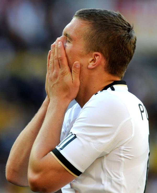 Lukas Podolski schlägt enttäuscht die Hände vor das Gesicht.