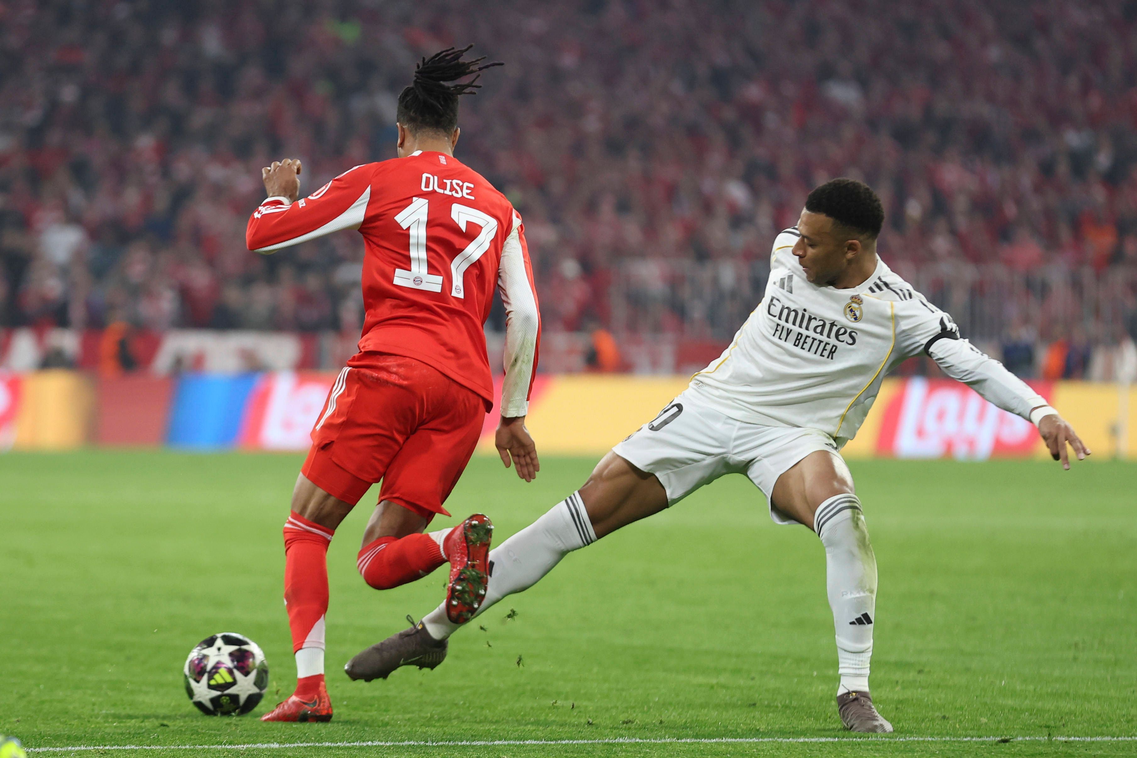 Michael Olise vom FC Bayern dribbelt an Real Madrids Kylian Mbappé vorbei.