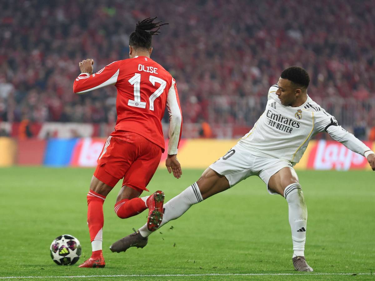 Michael Olise vom FC Bayern dribbelt an Real Madrids Kylian Mbappé vorbei.