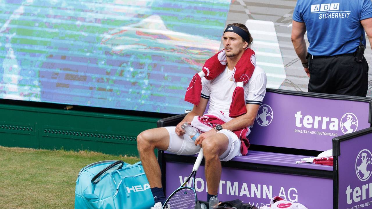 Alexander Zverev sitzt völlig fertig mit einem Kühlpad um den Hals auf der Bank beim Seitenwechsel.