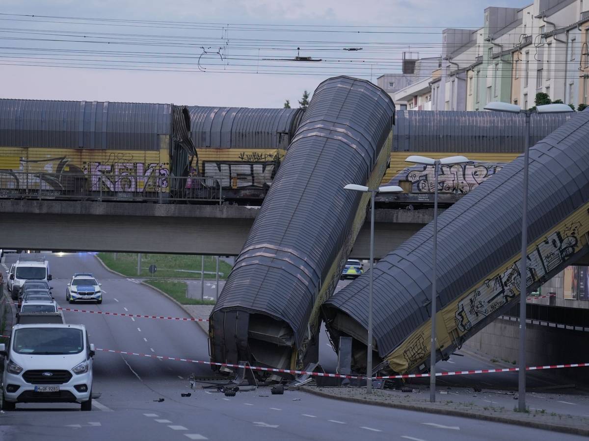 Zwei Waggons eines Güterzugs liegen auf einer Straße, nachdem sie von einer Brücke gestürzt sind.