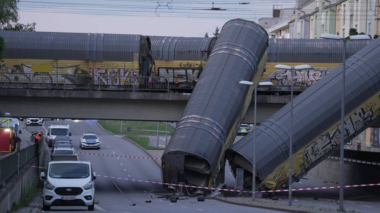 Zwei Waggons eines Güterzugs liegen auf einer Straße, nachdem sie von einer Brücke gestürzt sind.