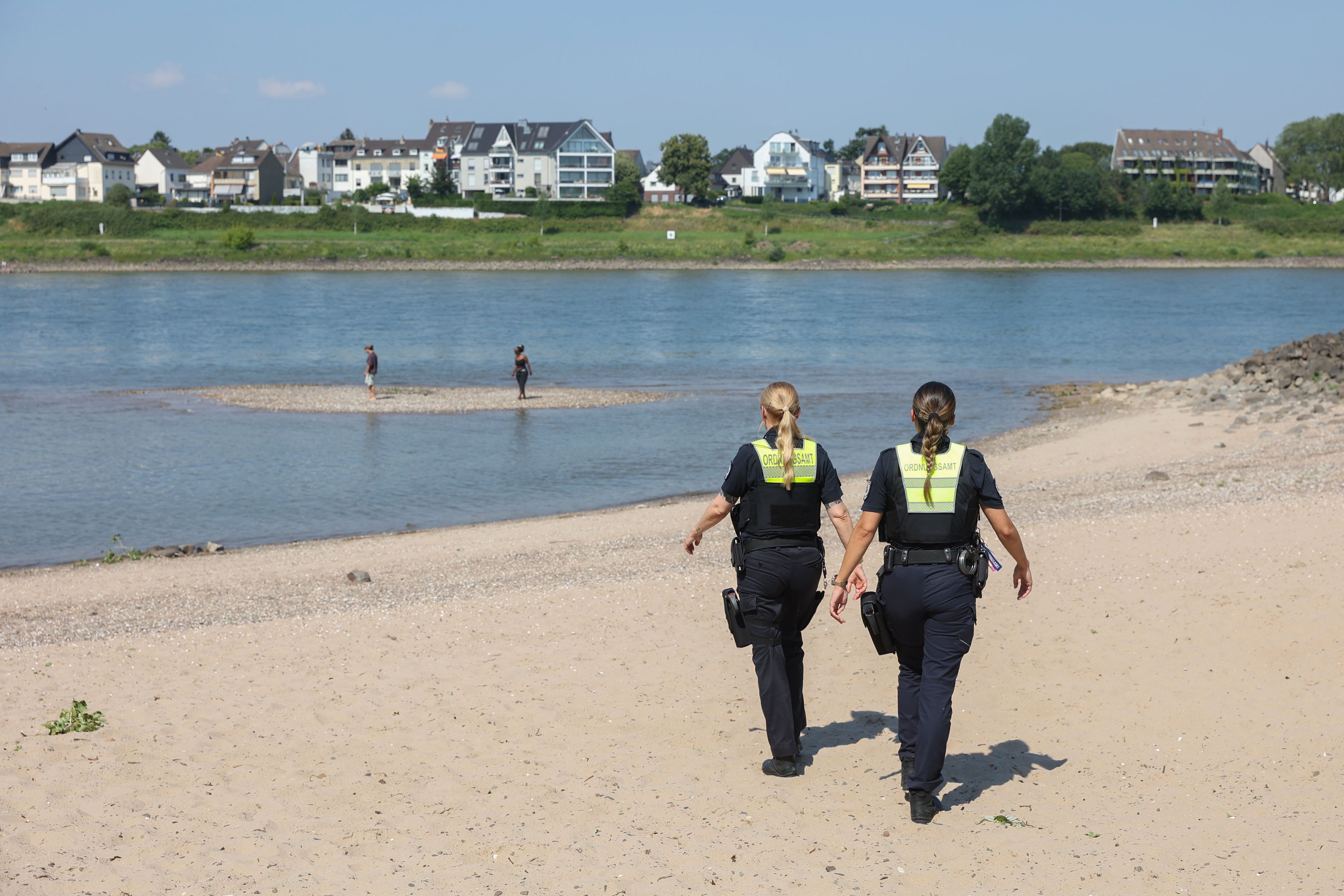 Mitarbeiterinnen des Ordnungsamts kontrollieren das Badeverbot im Rhein.
