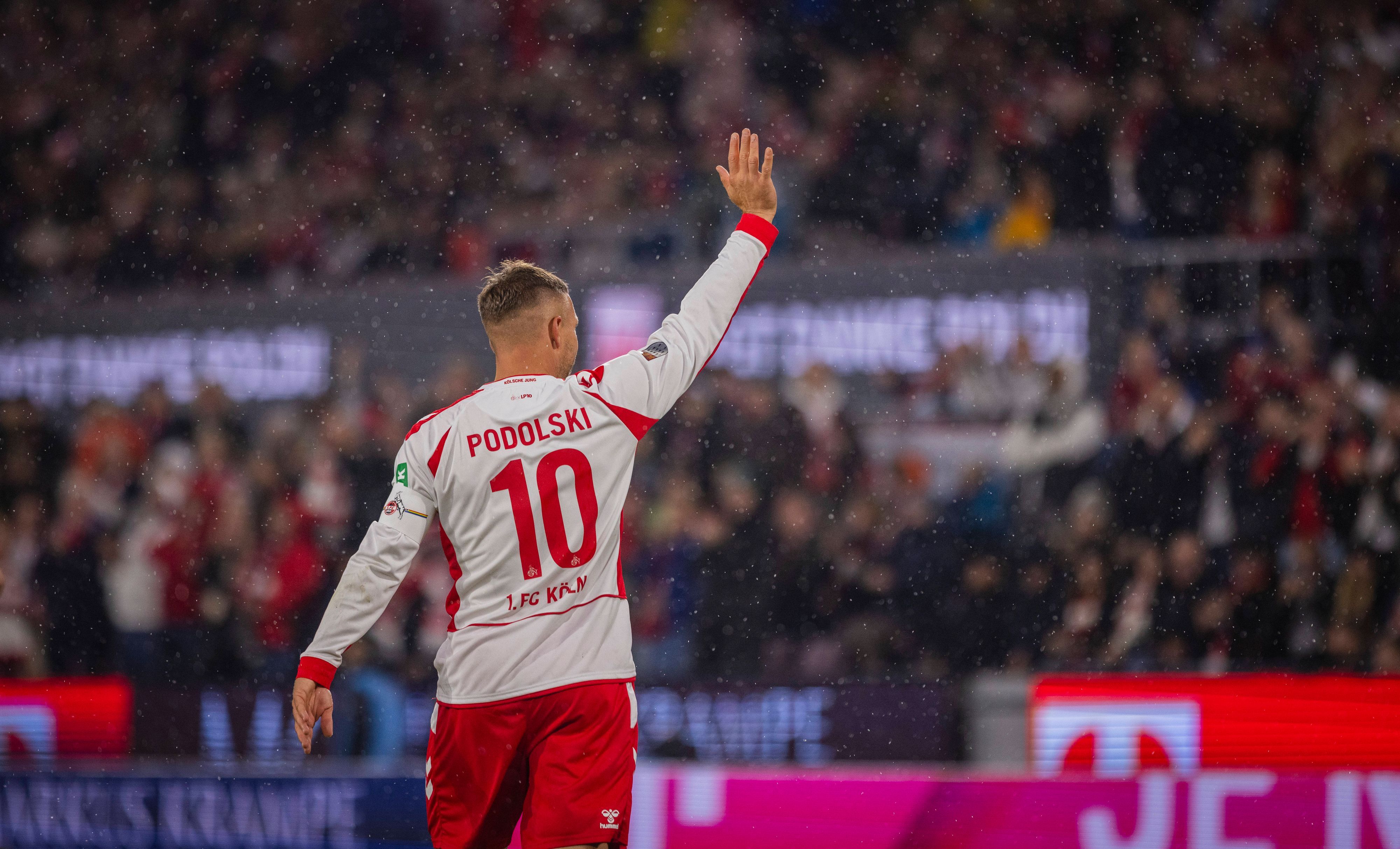 Lukas Podolski winkt rauf auf die Tribüne.