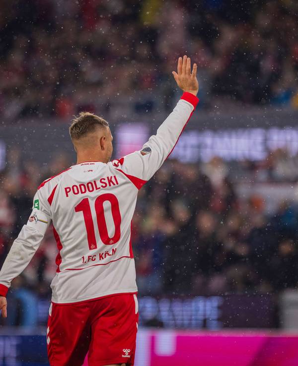 Lukas Podolski winkt rauf auf die Tribüne.