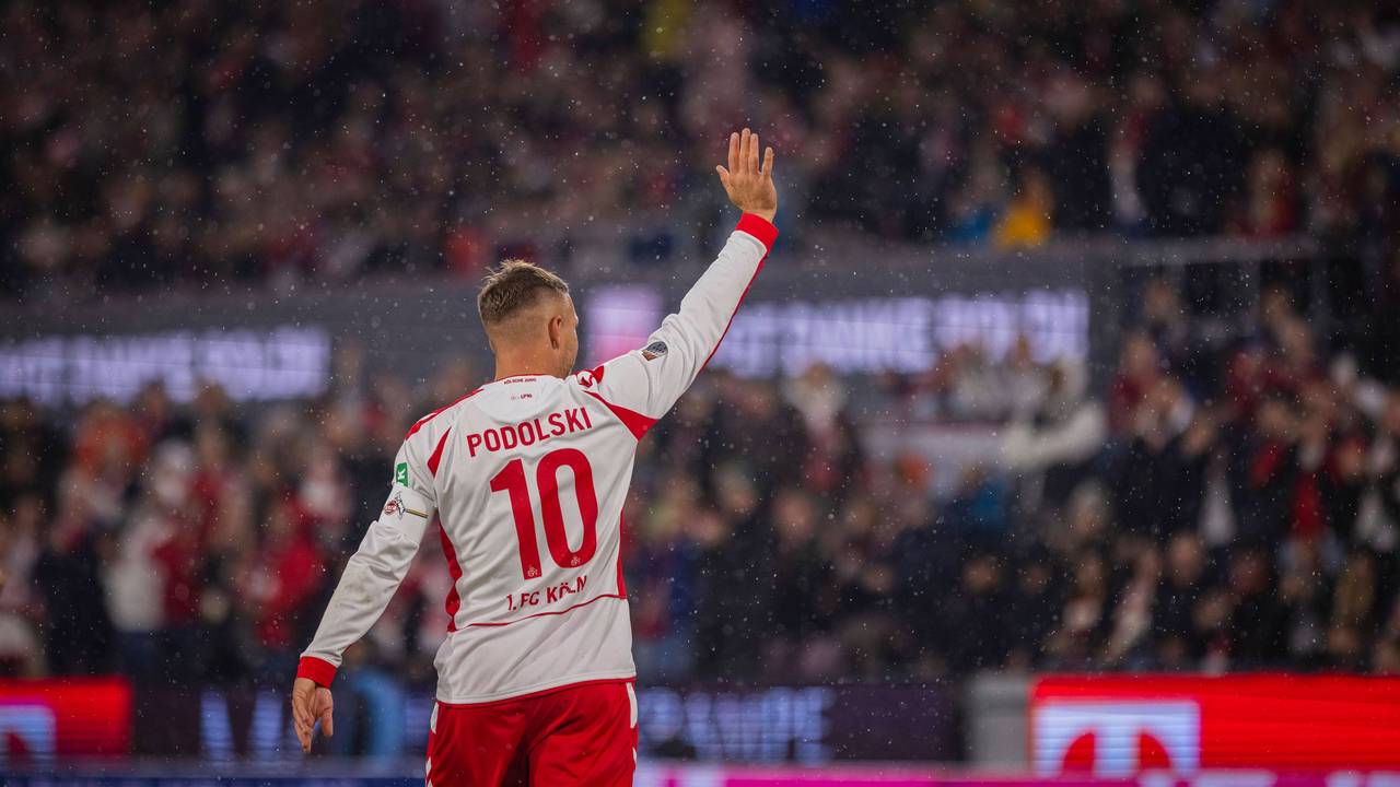 Lukas Podolski winkt rauf auf die Tribüne.
