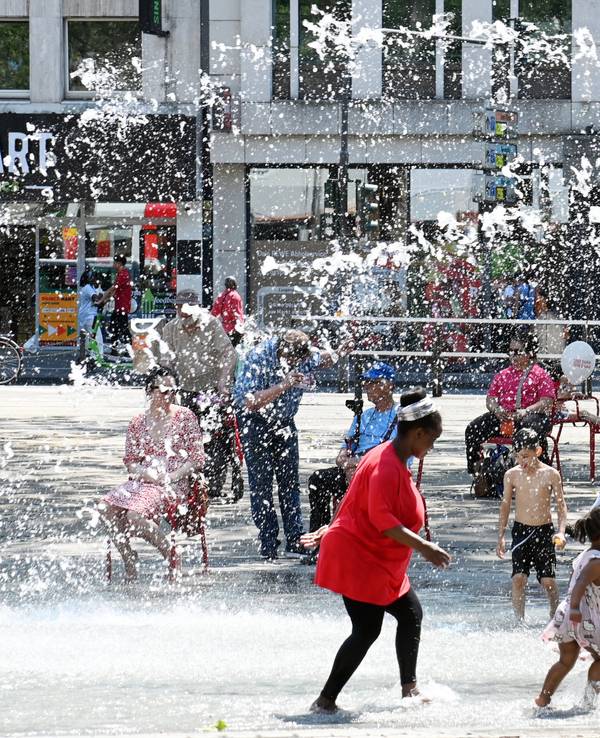 Hitzewelle in Köln: Am Neumarkt suchen die Menschen Abkühlung am Brunnen.