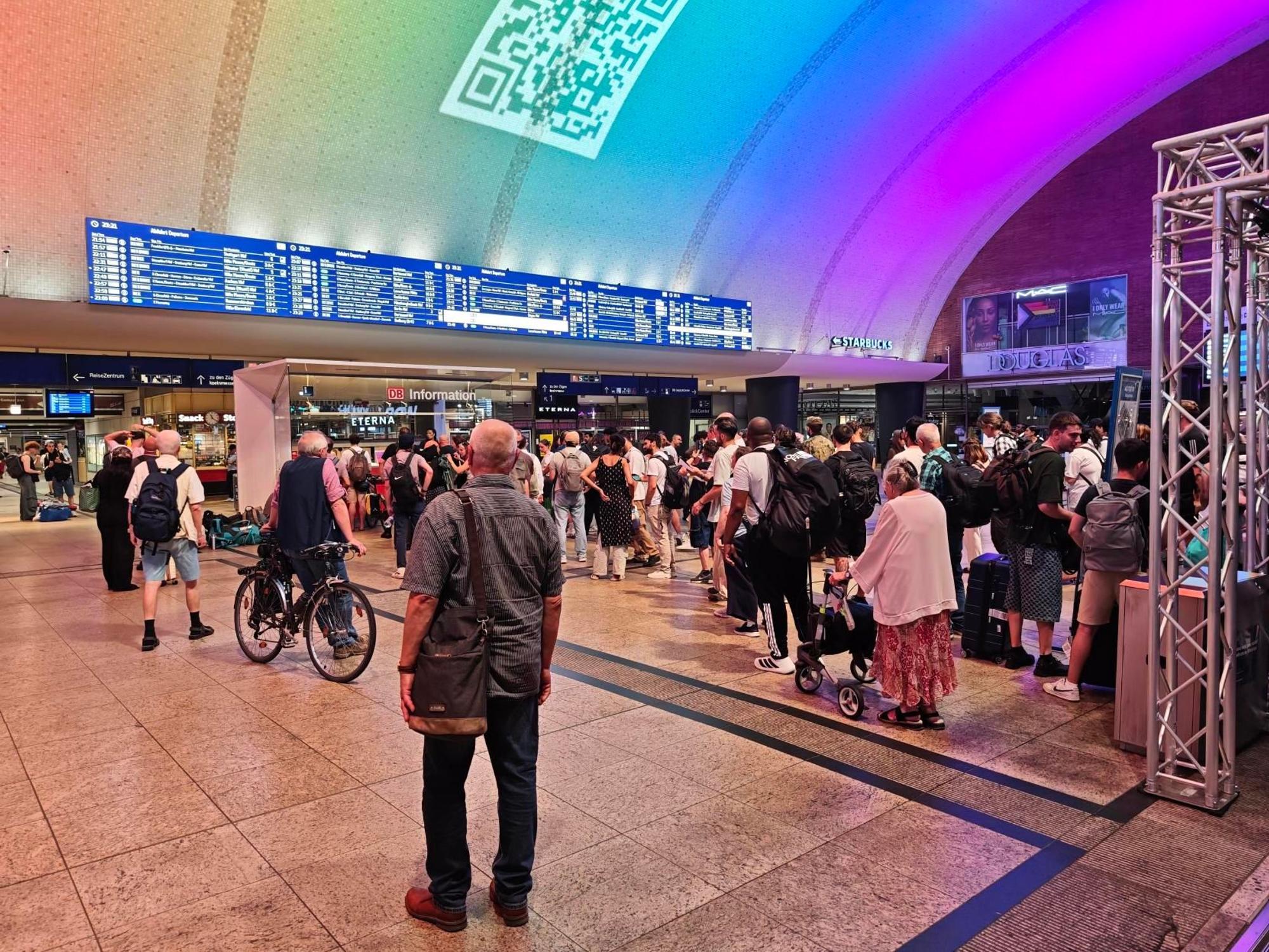 In der Bahnhofshalle des Kölner Hauptbahnhofs hatten sich vor der DB-Information rund 200 Menschen versammelt.