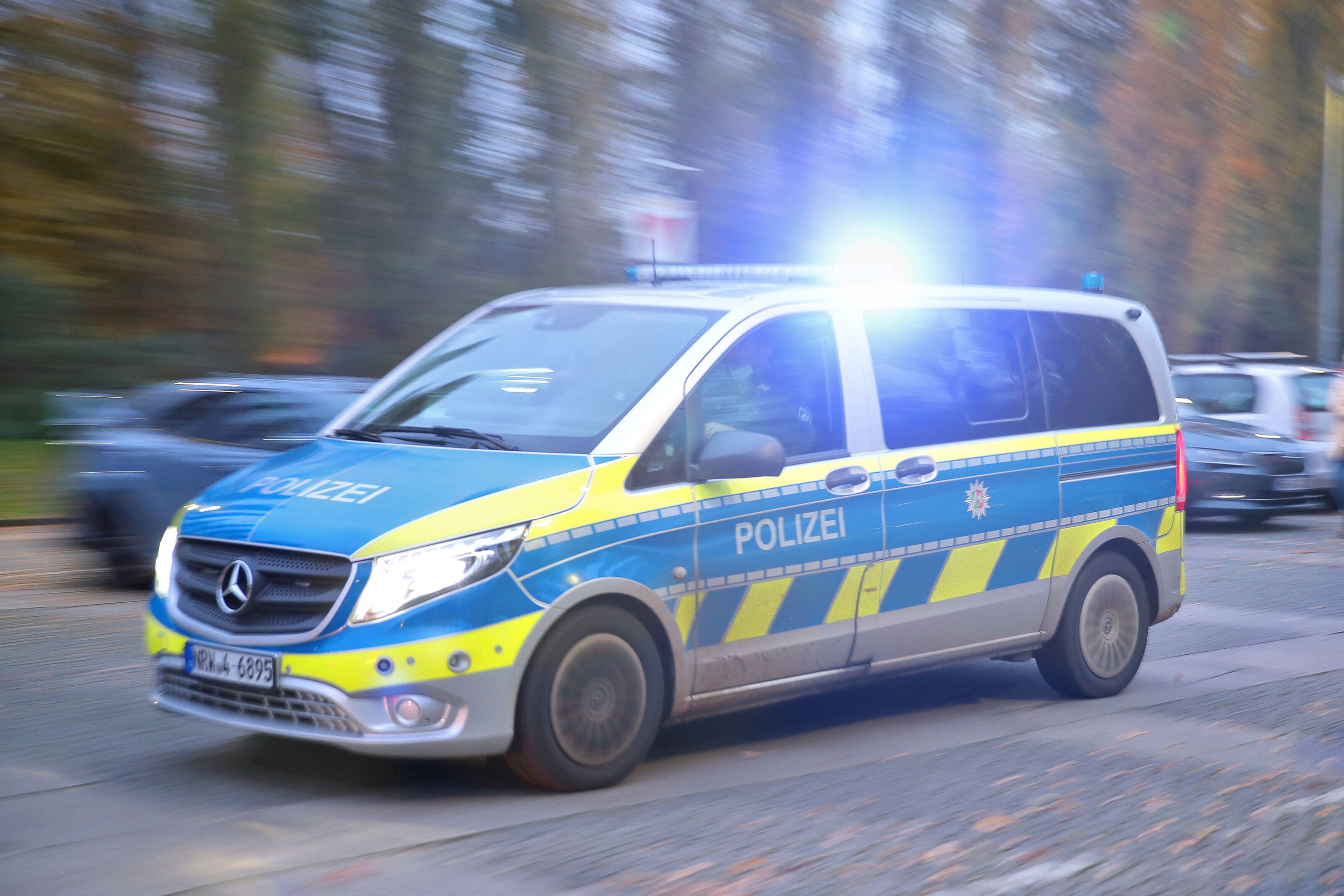 Ein Polizeiauto fährt mit Blaulicht durch eine Straße. (Symbolfoto)