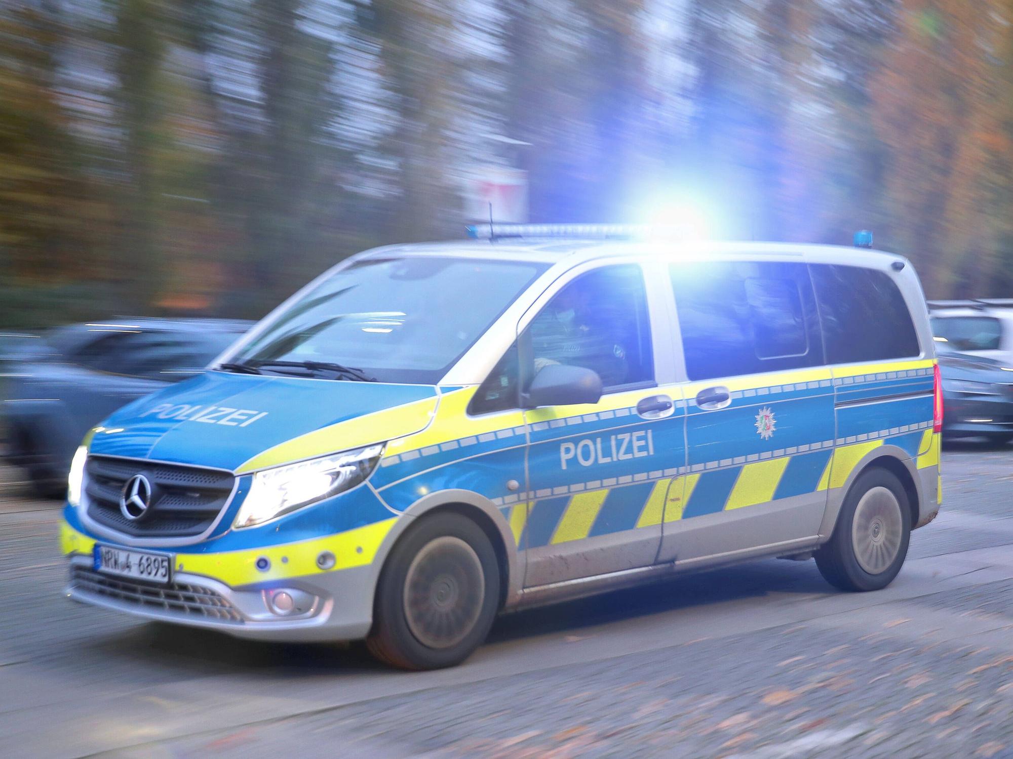 Ein Polizeiauto fährt mit Blaulicht durch eine Straße. (Symbolfoto)