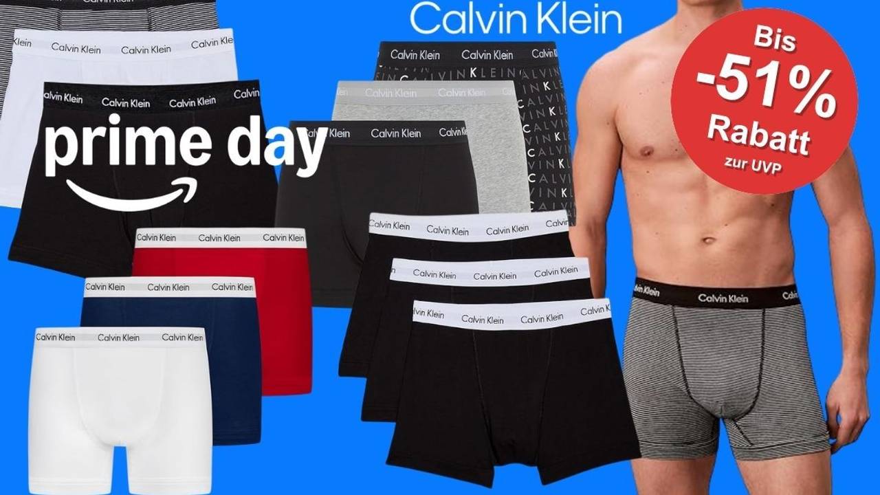 Calvin Klein Herren Boxershorts in verschiedenen Farben (Schwarz, Weiß, Rot, Navy, Grau) mit Amazon Prime Day Logo und rotem Rabatt-Sticker (-51% zur UVP) auf blauem Hintergrund.