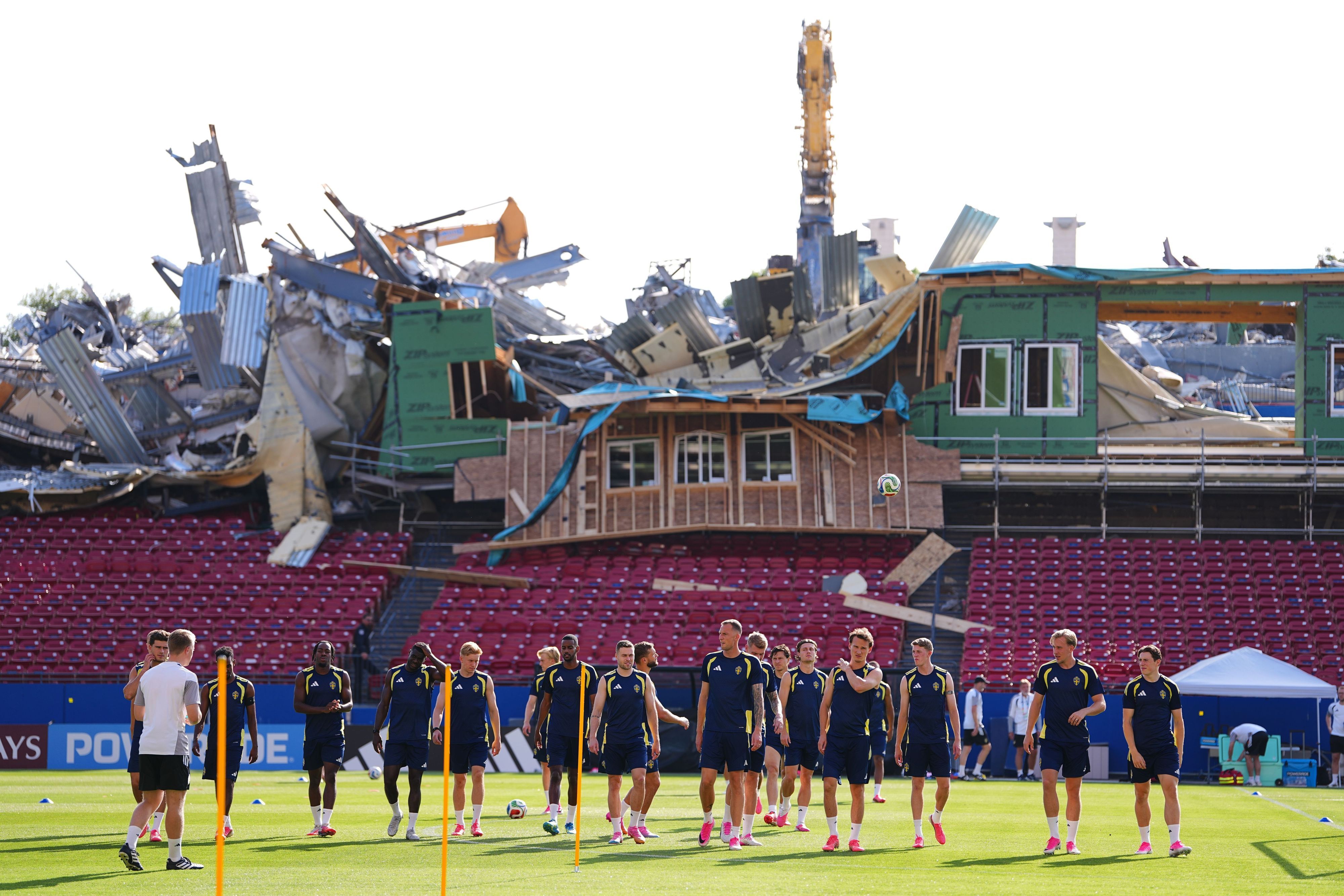 Von den Tribünen des Toyota Stadiums aus sind Abrissarbeiten zu sehen, während die schwedischen Spieler vor ihrem WM-Gruppenspiel (Gruppe F) eine Trainingseinheit absolvieren.