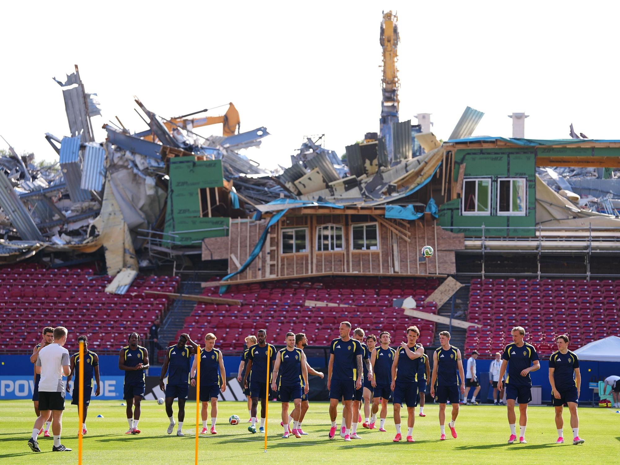 Von den Tribünen des Toyota Stadiums aus sind Abrissarbeiten zu sehen, während die schwedischen Spieler vor ihrem WM-Gruppenspiel (Gruppe F) eine Trainingseinheit absolvieren.