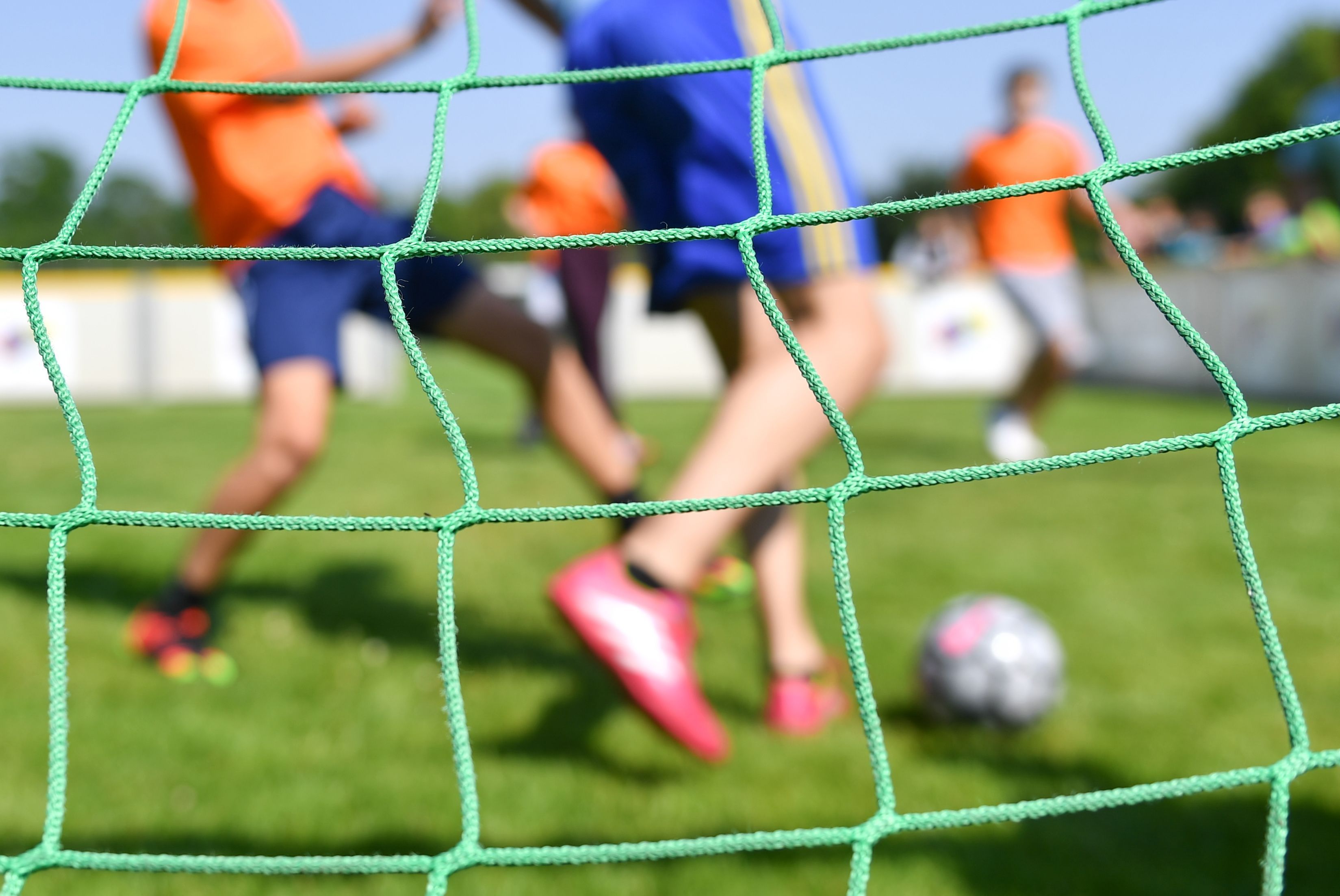 Kinder spielen auf einem Kleinfeld Fußball.