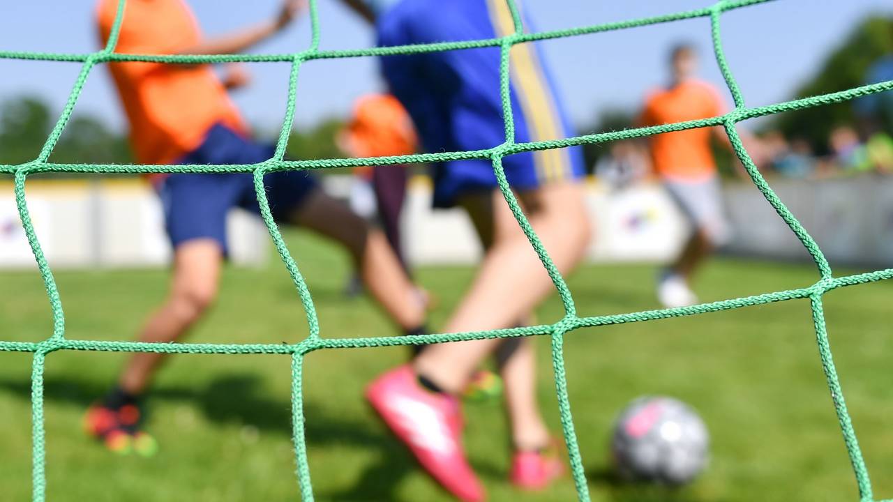 Kinder spielen auf einem Kleinfeld Fußball.