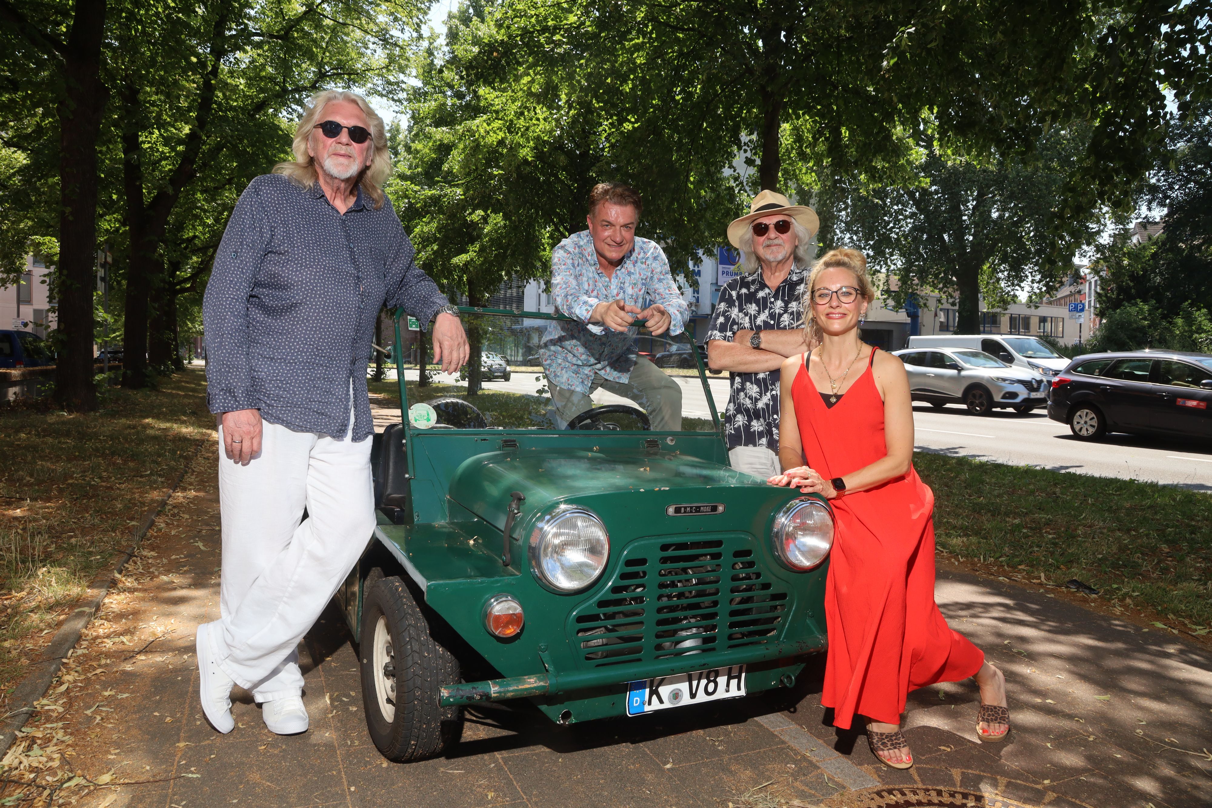 Jürgen Fritz, Linus, Tommy Engel und Kirstin Hesse posieren an einem Oldtimer.