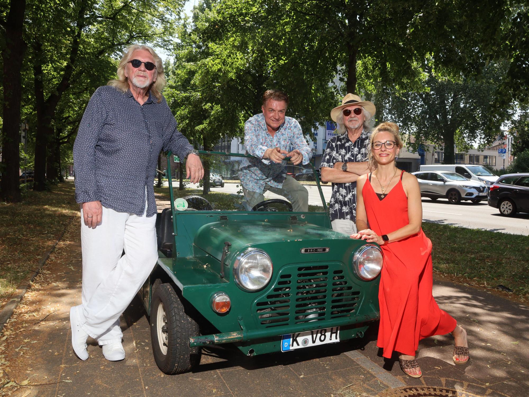 Jürgen Fritz, Linus, Tommy Engel und Kirstin Hesse posieren an einem Oldtimer.