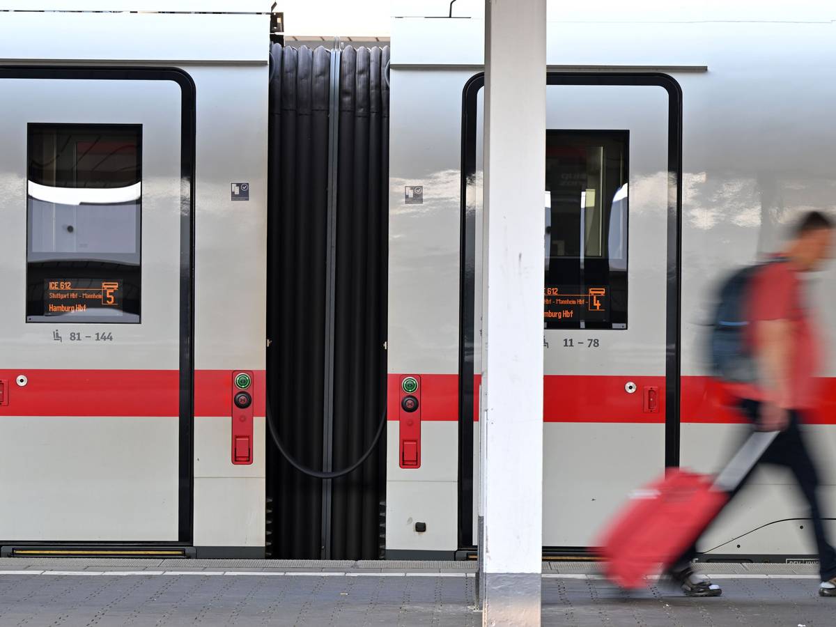 Ein Passagier läuft am Hauptbahnhof München an einem ICE-Zug vorbei. Die Deutsche Bahn rät aktuell vom Reisen ab.