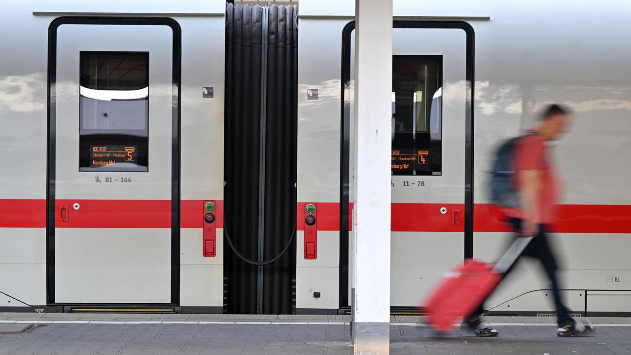 Ein Passagier läuft am Hauptbahnhof München an einem ICE-Zug vorbei. Die Deutsche Bahn rät aktuell vom Reisen ab.