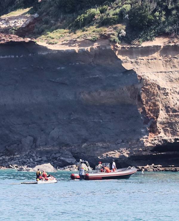 Rettungskräfte suchen von Booten aus nach einer vermissten Person in der Nähe eines riesigen Küstenabschnitts. Am Mittwochabend ist ein großer Felsen von einer Steilküste abgebrochen und ins Meer gestürzt, wobei ein Taucher ums Leben kam und ein weiterer vermisst wird.