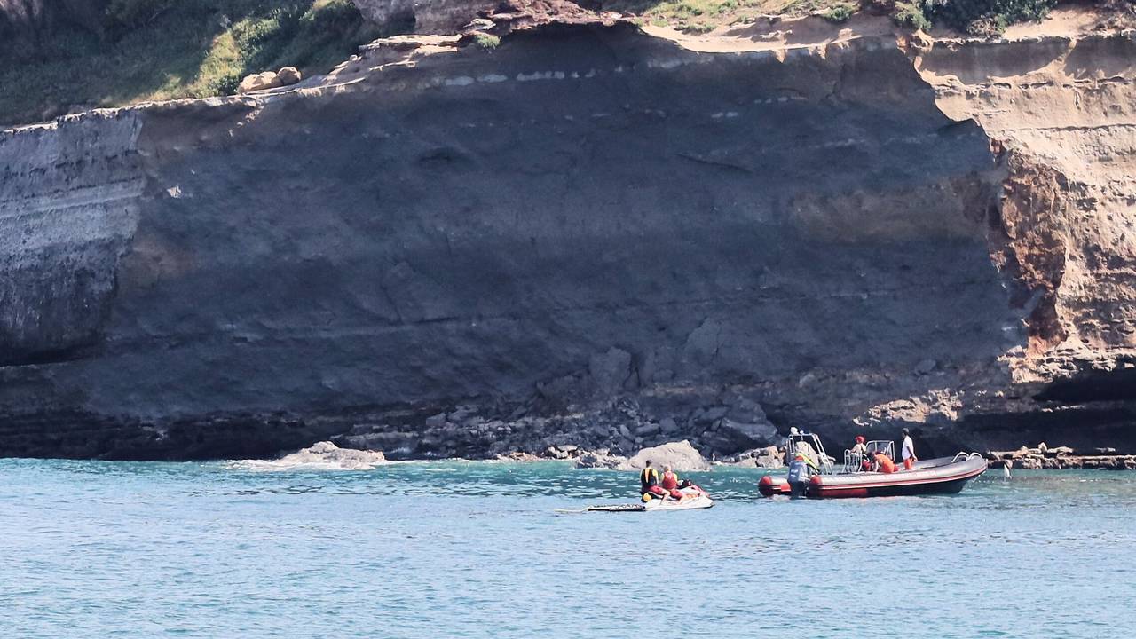 Rettungskräfte suchen von Booten aus nach einer vermissten Person in der Nähe eines riesigen Küstenabschnitts. Am Mittwochabend ist ein großer Felsen von einer Steilküste abgebrochen und ins Meer gestürzt, wobei ein Taucher ums Leben kam und ein weiterer vermisst wird.