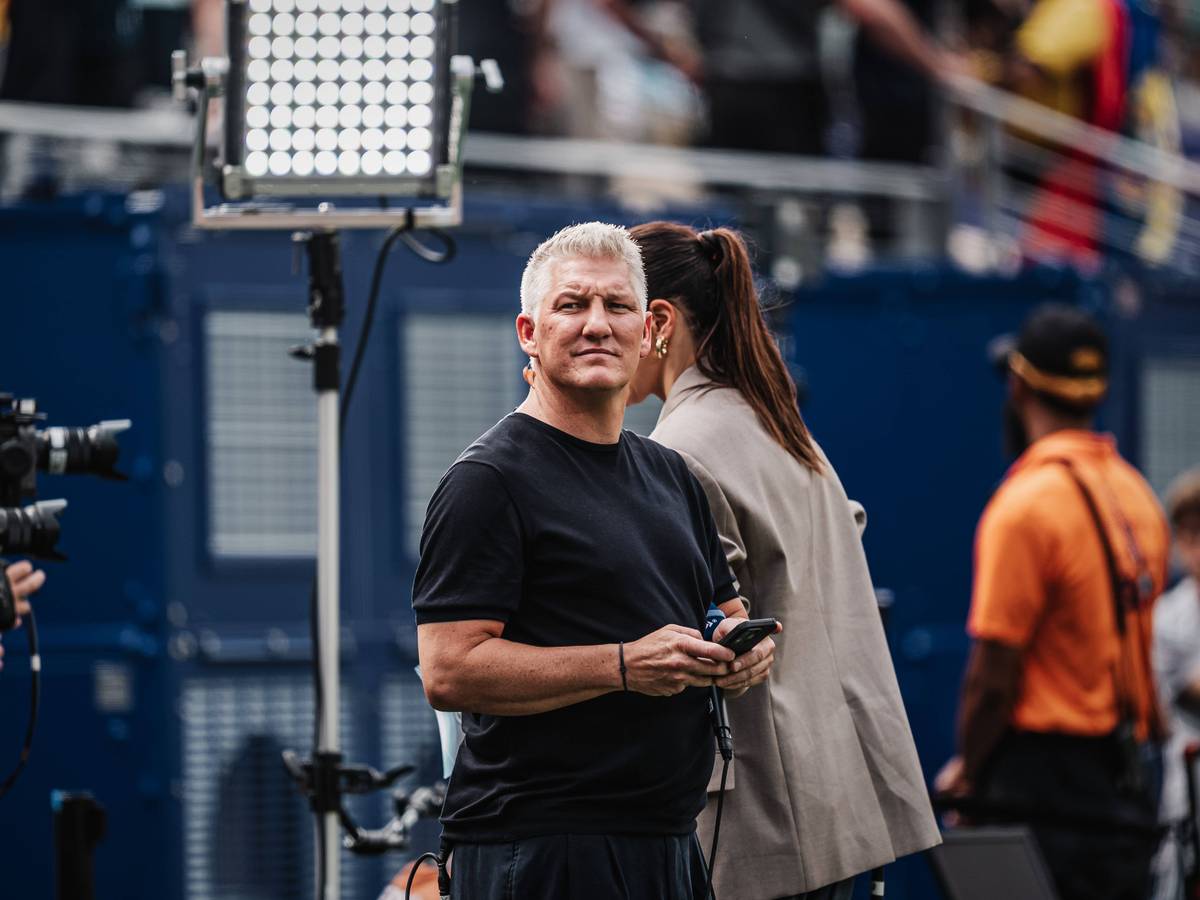 ARD-Experte Bastian Schweinsteiger mit Handy am Spielfeldrand.