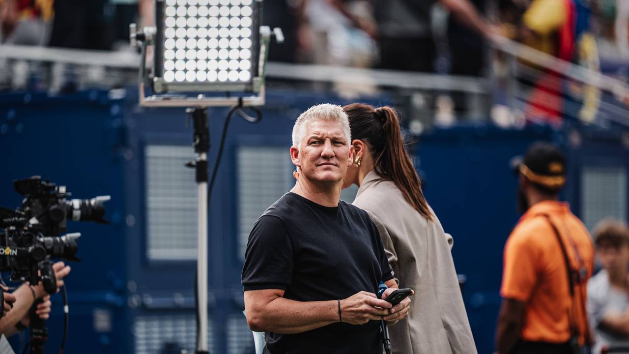 ARD-Experte Bastian Schweinsteiger mit Handy am Spielfeldrand.
