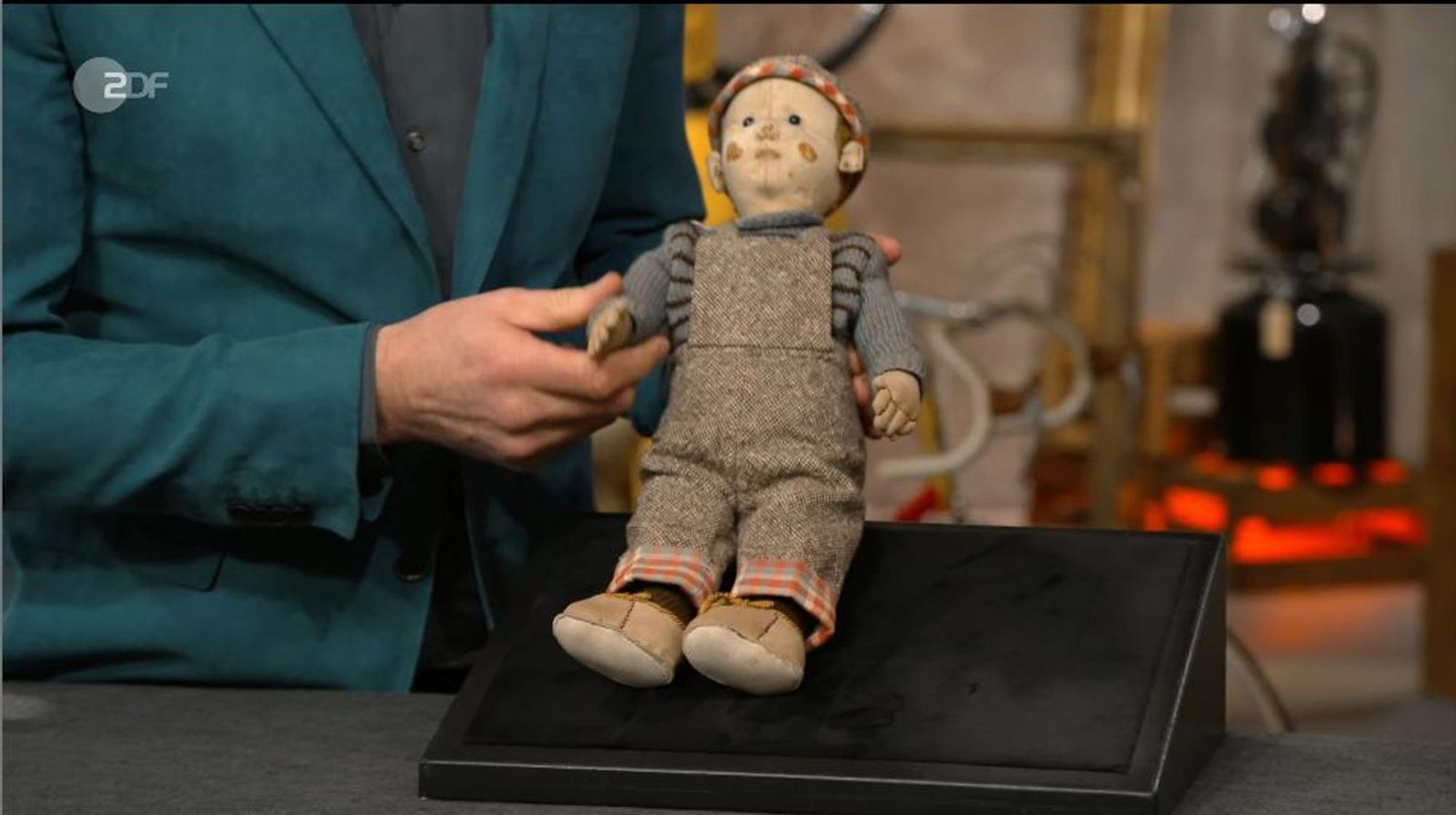 Das von Horst Lichter als „süß“ beschriebene Exemplar entpuppt sich als ein antikes Spielzeug, das von dem Verkäufer Dieter angeboten wird. Er und seine Frau Gabi besuchen gemeinsam die ZDF-Sendung, um dort seine alte Puppe namens Hanno zu verkaufen. (Bild: ZDF)