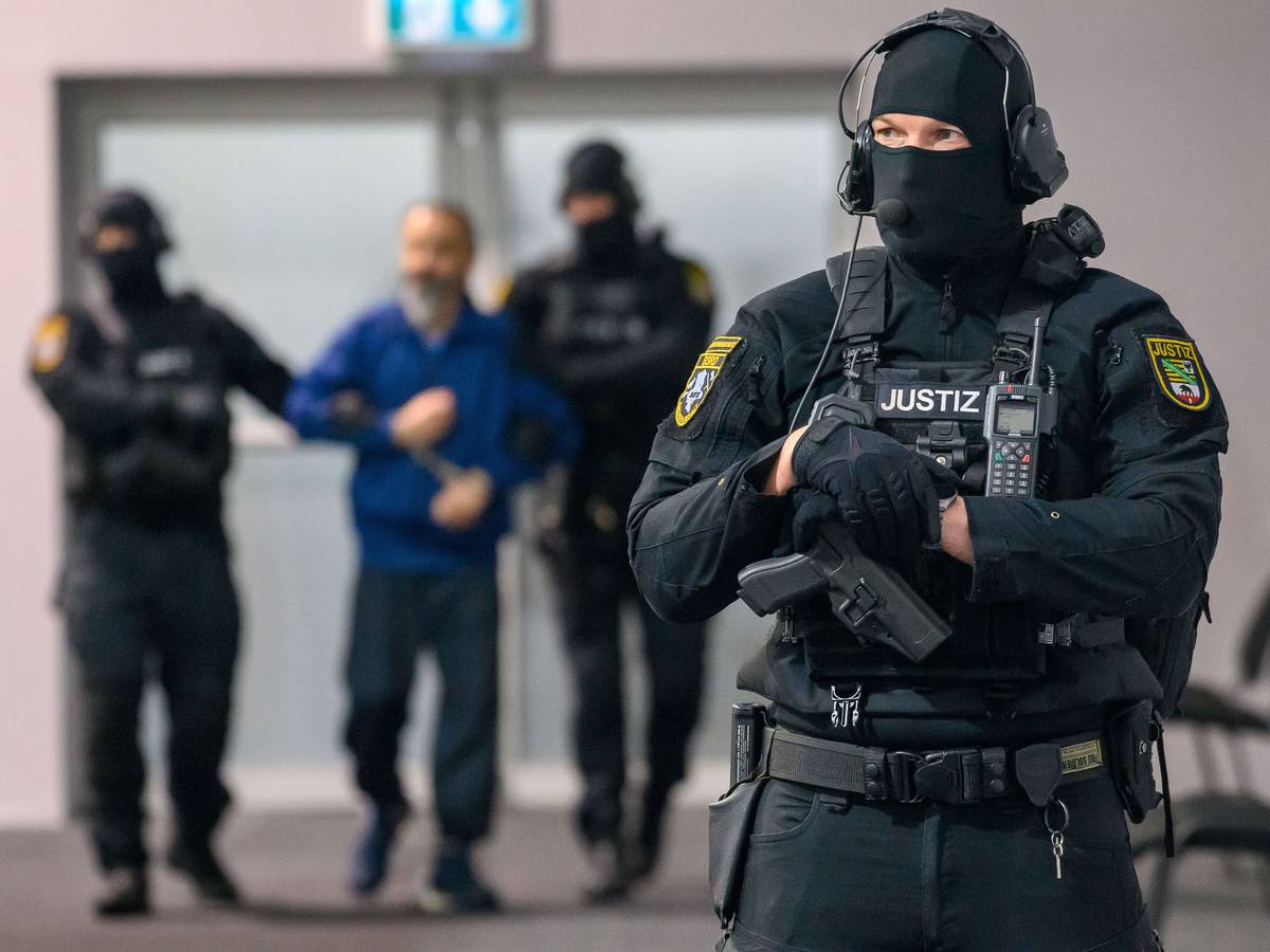 Justizbeamte führen den Angeklagten Taleb A. in den Gerichtssaal des temporären Gerichtsgebäudes des Landgerichts Magdeburg.