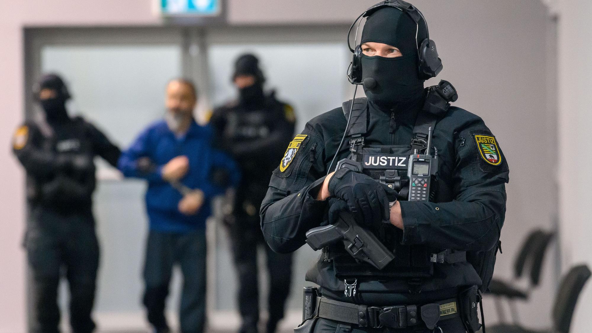 Justizbeamte führen den Angeklagten Taleb A. in den Gerichtssaal des temporären Gerichtsgebäudes des Landgerichts Magdeburg.