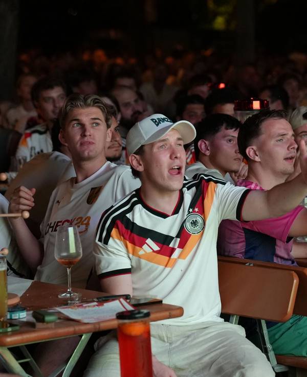 Fans verfolgen das Spiel beim Public Viewing und reagieren enttäuscht auf eine Spielszene.