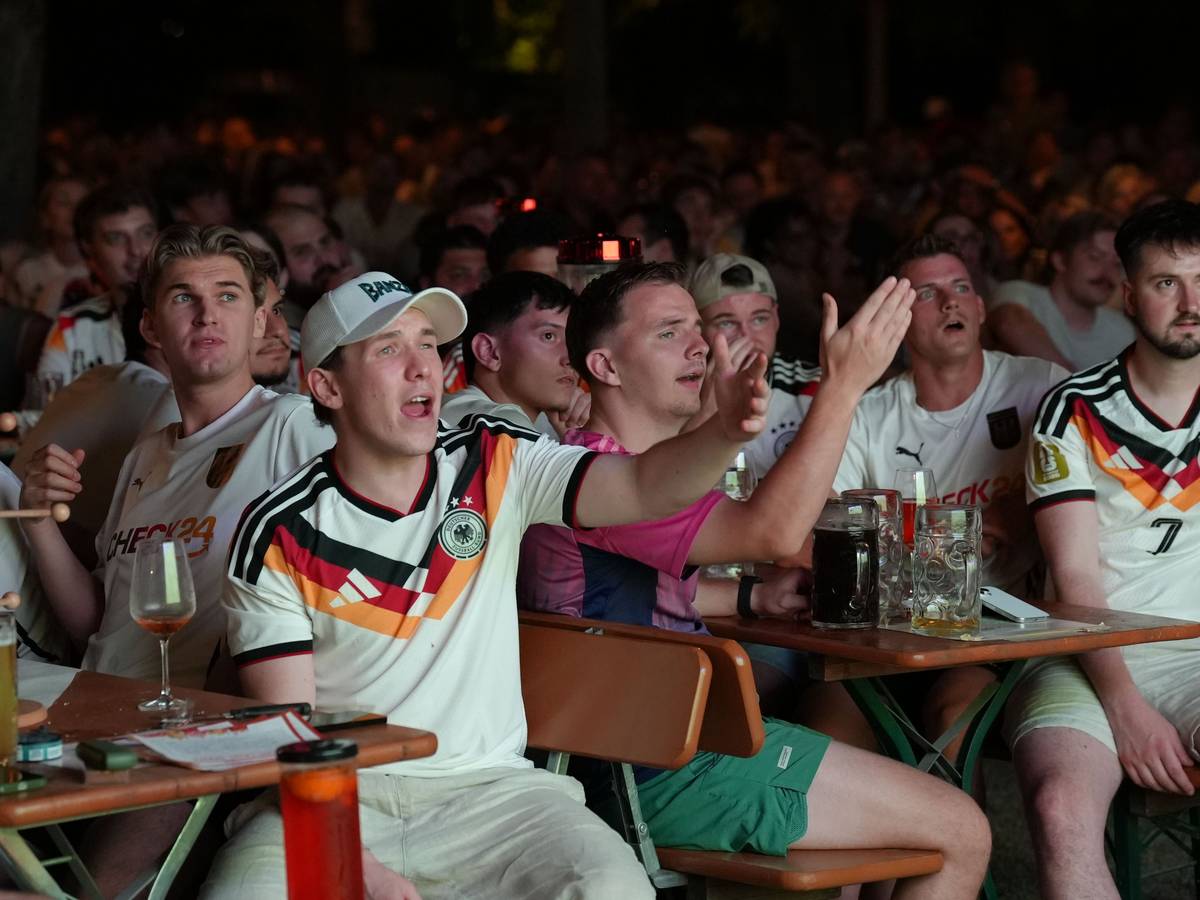 Fans verfolgen das Spiel beim Public Viewing und reagieren enttäuscht auf eine Spielszene.