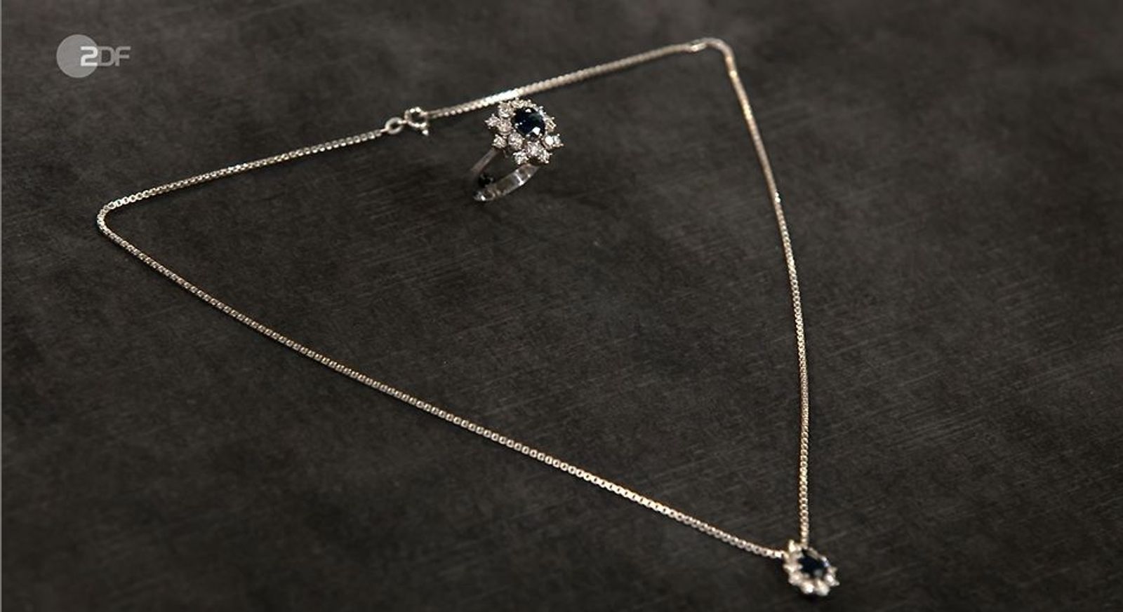In der Trödelsendung bringen Mutter Alice und Tochter Milena einen Ring und eine Veneziakette mit Anhänger zum Verkauf mit. Der aus 585er Weißgold bestehende Schmuck wurde in den 1970er-Jahren in Deutschland gefertigt. Der Wert wird von Patrick Lessner auf etwa 1.200 bis 1.400 Euro geschätzt. Elisabeth Nüdling erwirbt die Stücke für 1.300 Euro. (Bild: ZDF)