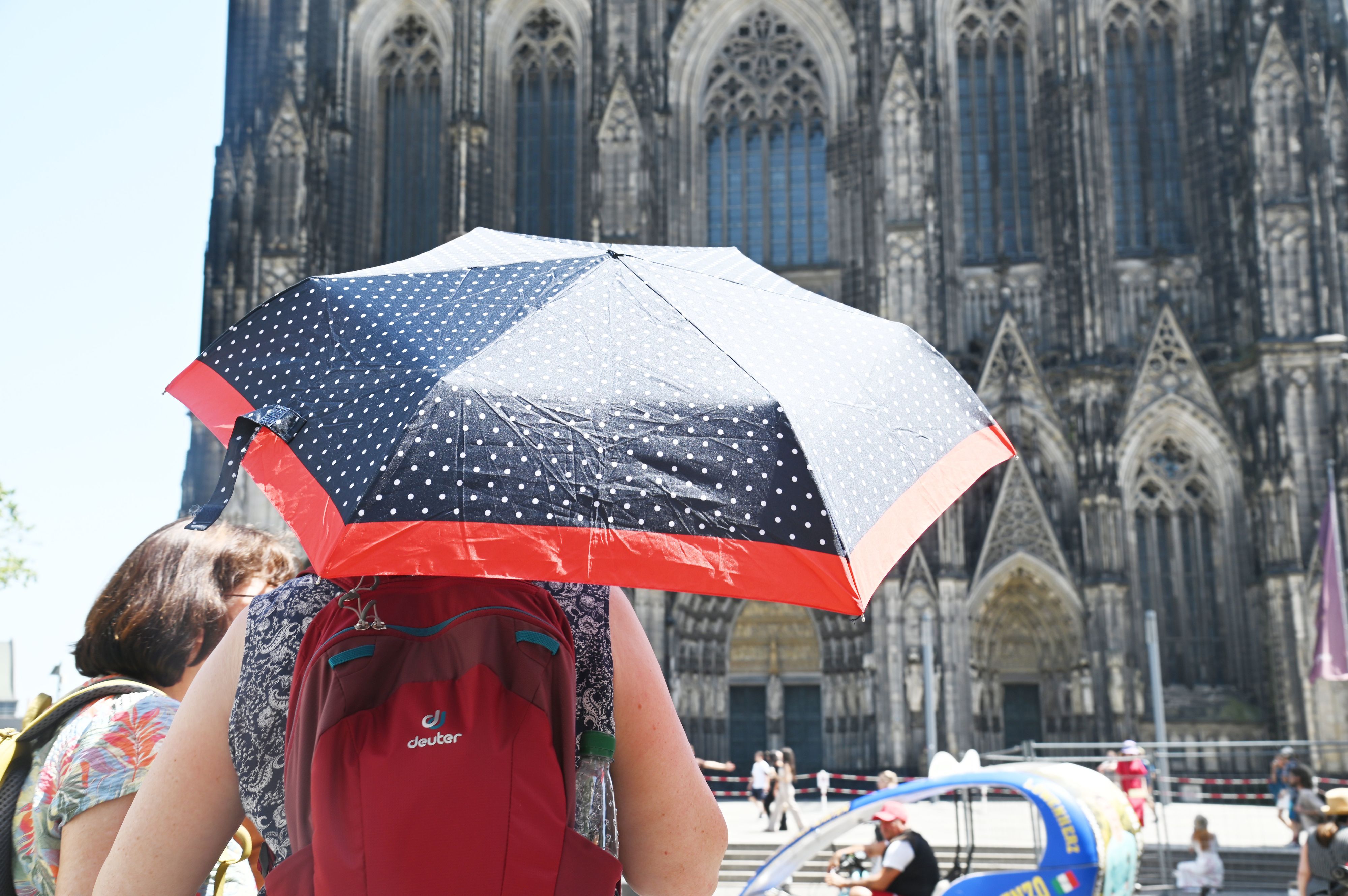Eine Person schützt sich mit einem Schirm vor der Sonne.