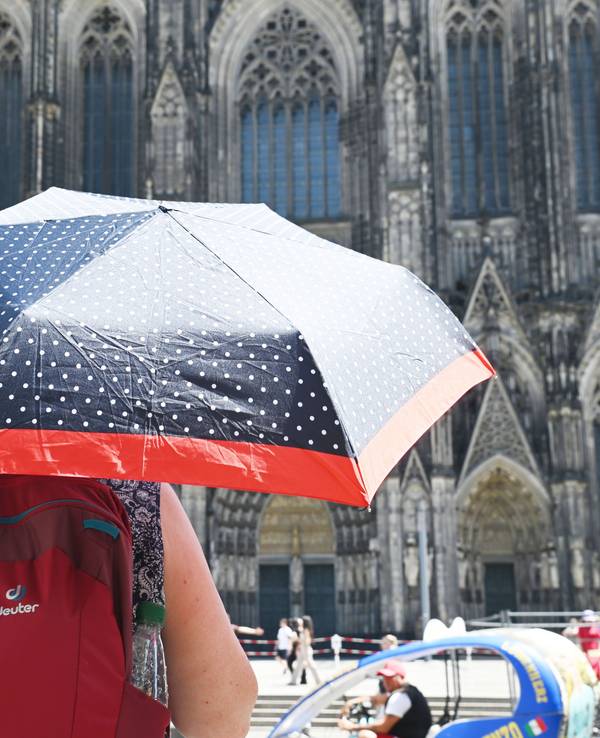 Eine Person schützt sich mit einem Schirm vor der Sonne.
