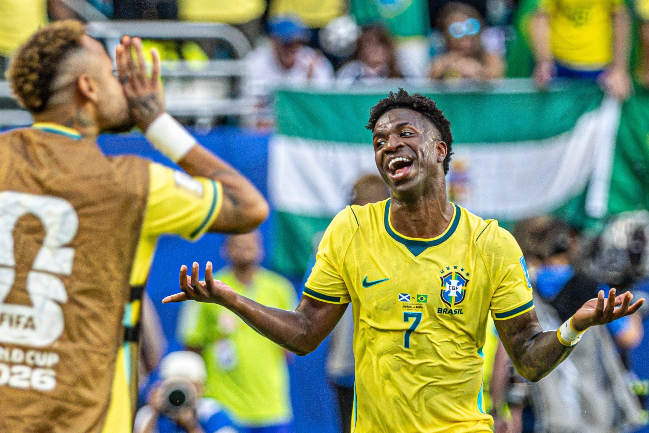 Vinicius Junior hebt die Arme und lacht.