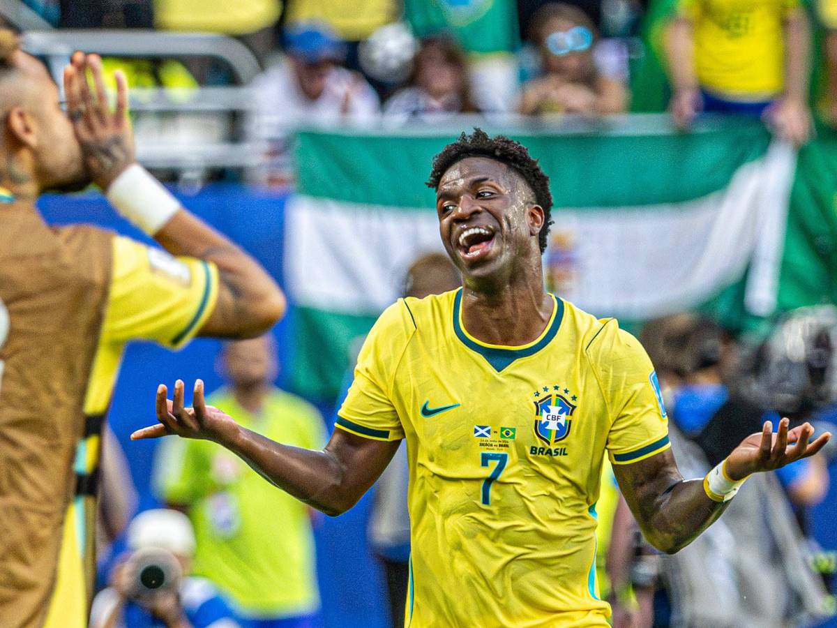Vinicius Junior hebt die Arme und lacht.