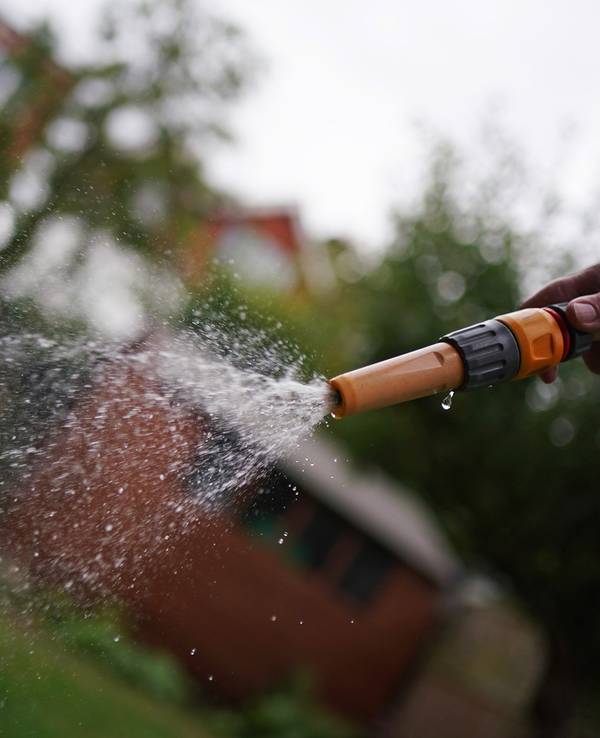 Ein Wasserschlauch in einem Garten. In Neuss hat sich ein siebenjähriger Junge schwere Verbrühungen zugezogen. (Symbolfoto)