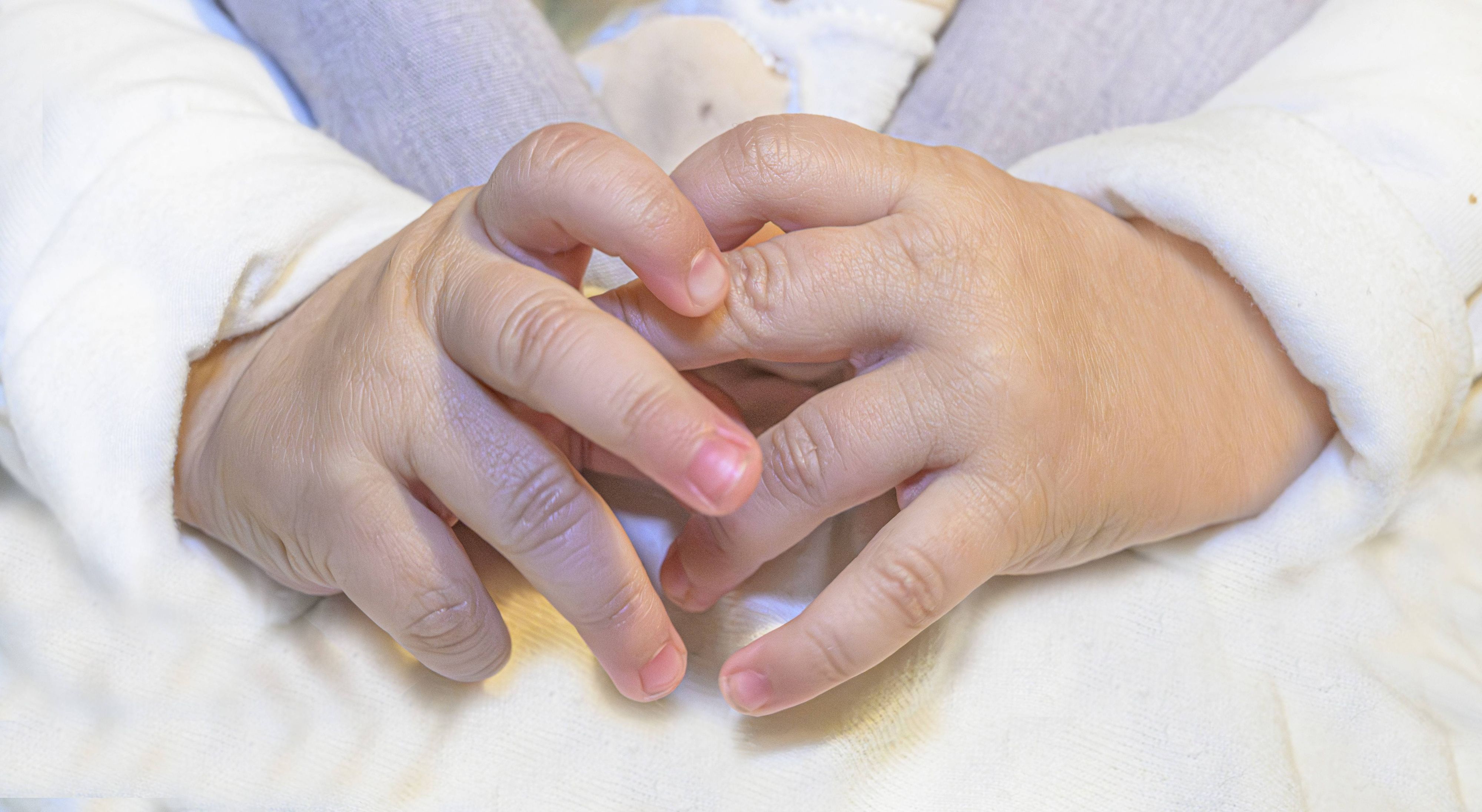 Das Symbolfoto zeigt die Nahaufnahme von Babyhänden. In Lüdenscheid wurde ein Neugeborenes von einer unbekannten Frau aus einem Krankenhaus mitgenommen.