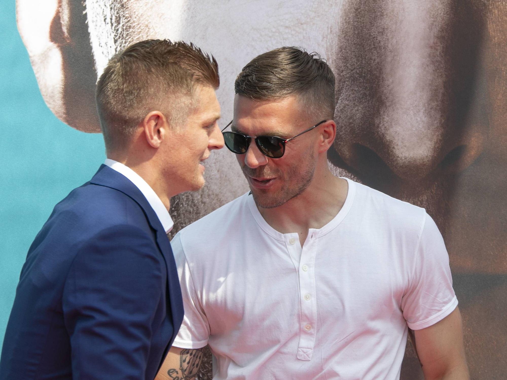 Lukas Podolski (r.) und Toni Kroos begrüßen sich.