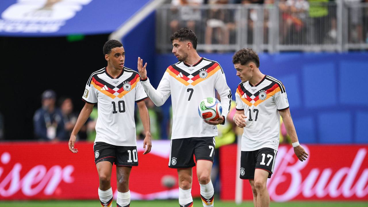 Jamal Musiala, Kai Havertz und Florian Wirtz diskutieren nachdenklich im DFB-Trikot.