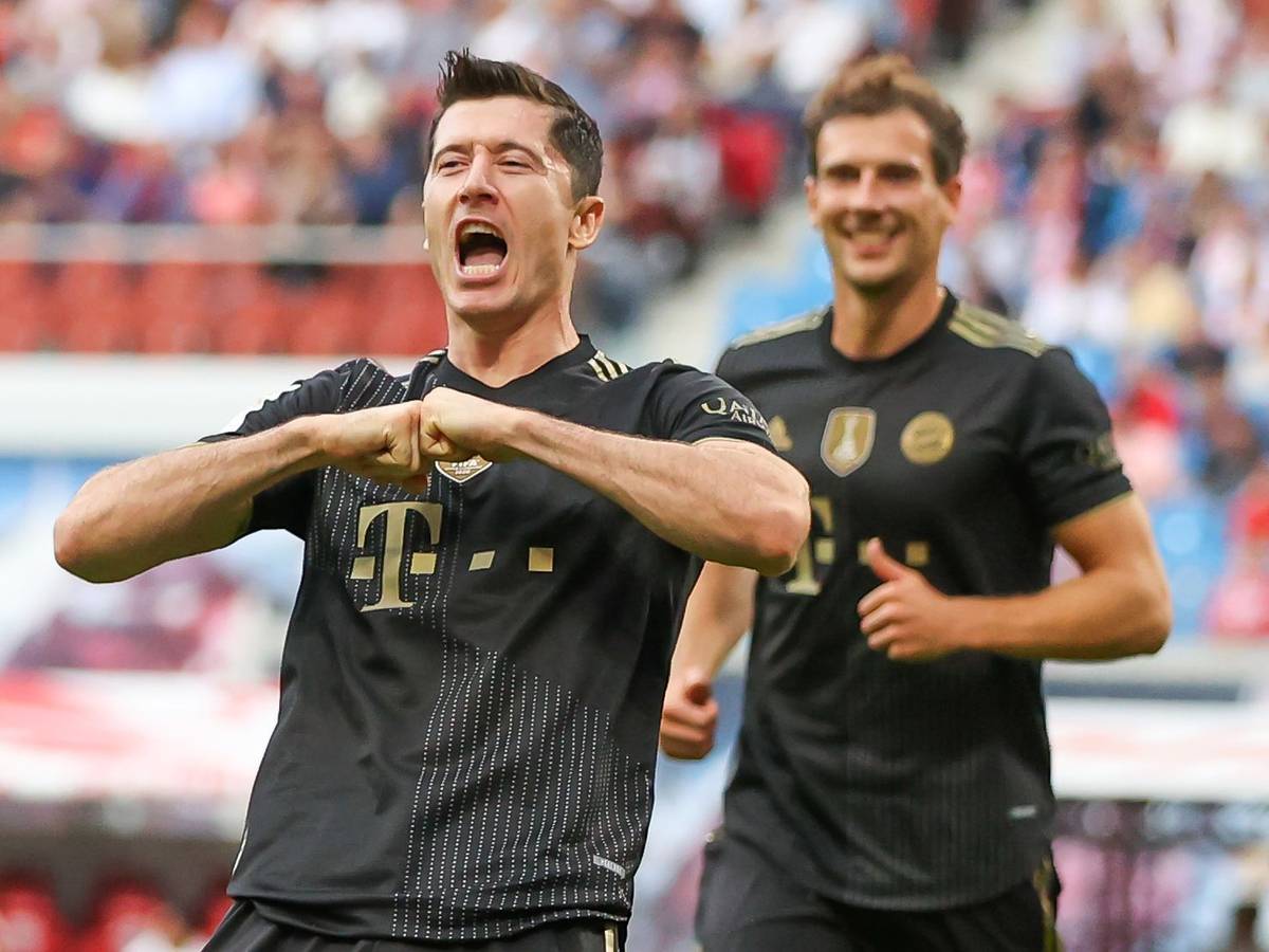 Robert Lewandowski jubelt im Bayern-Trikot, im HIntergrund grinst Leon Goretzka.