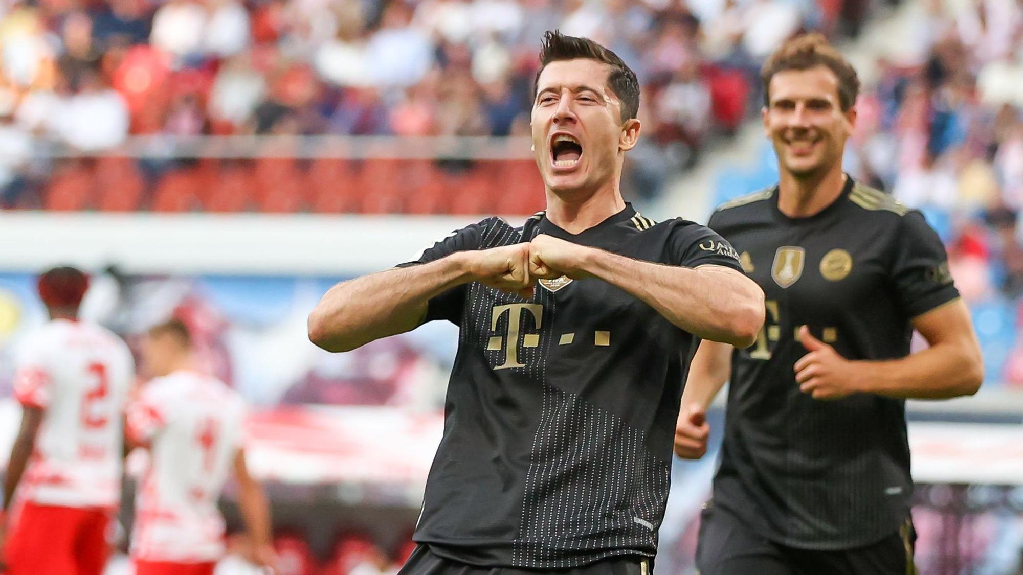 Robert Lewandowski jubelt im Bayern-Trikot, im HIntergrund grinst Leon Goretzka.