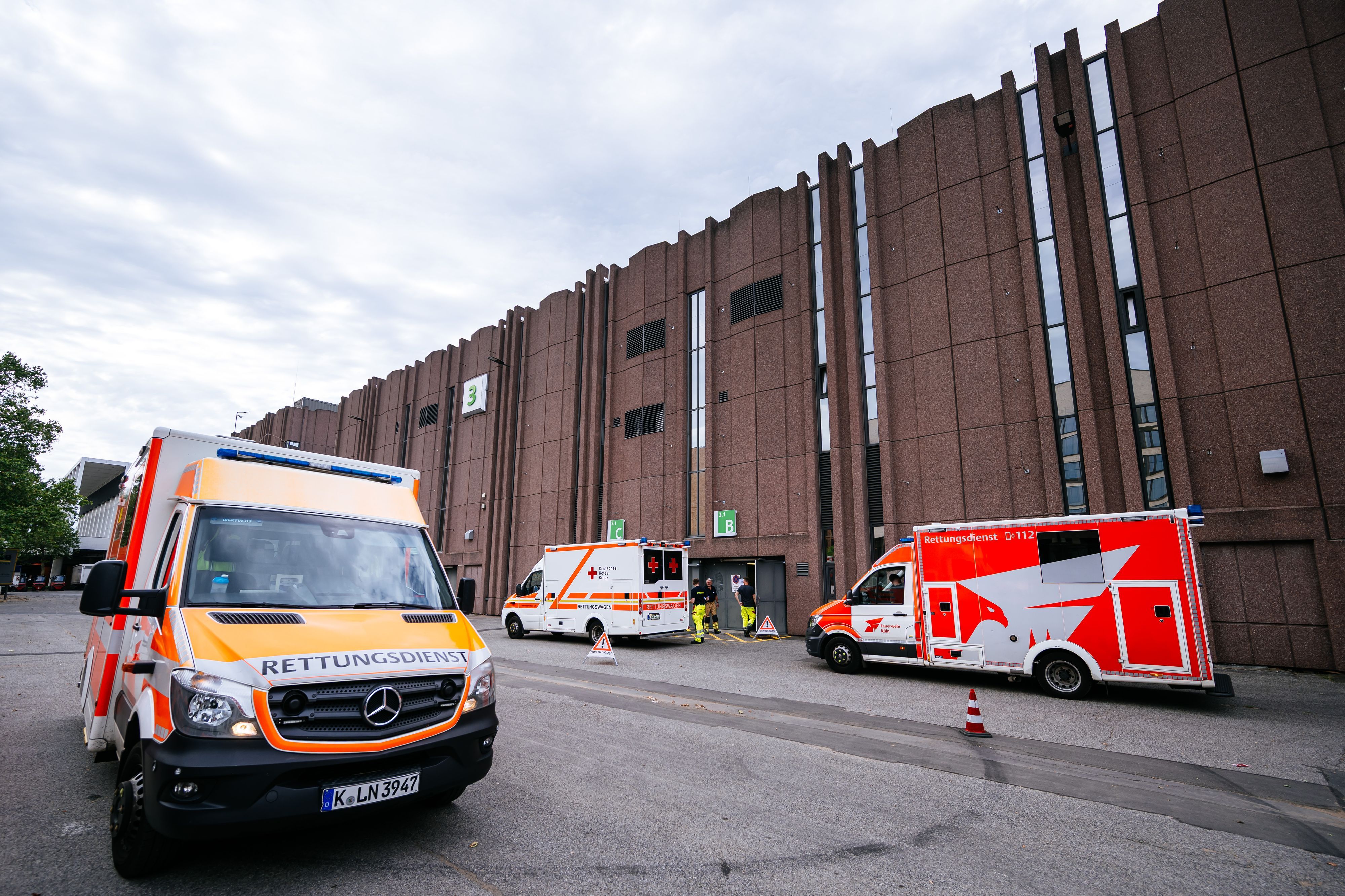 Rettungswagen stehen vor dem Notfallversorgungszentrum in einer Messehalle.