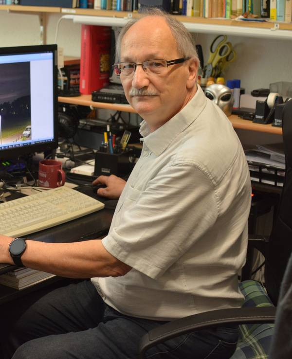 UFO-Forscher Hans-Werner Peiniger sitzt vor zwei Computermonitoren an einem Schreibtisch und wertet Aufnahmen aus.